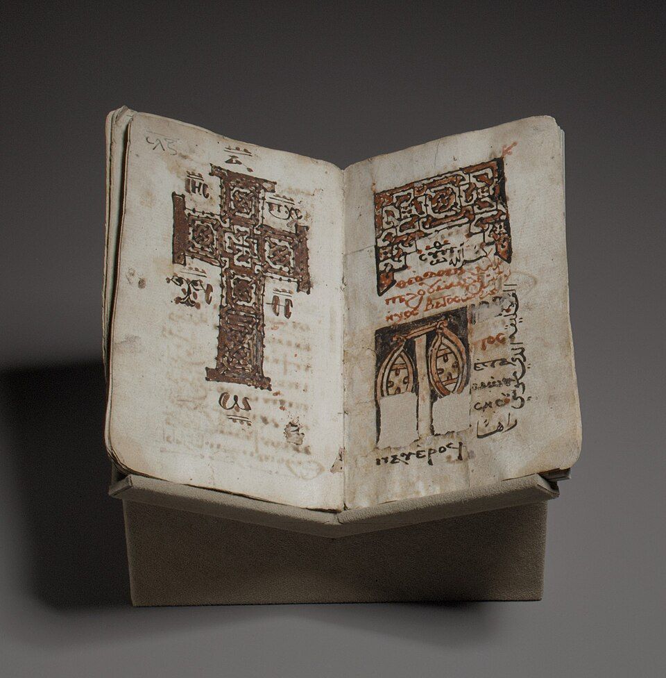 Open Coptic liturgical codex with a large cross