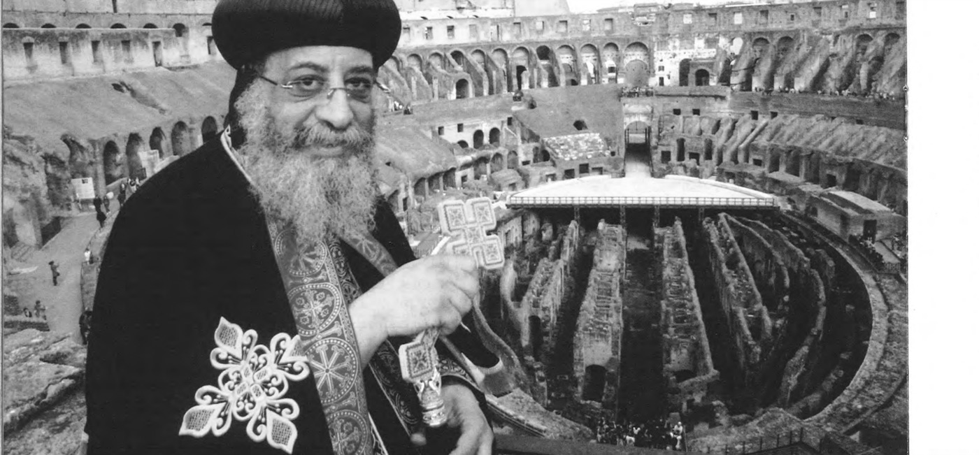 Pope Tawadros II holding a cross, with the Colosseum behind